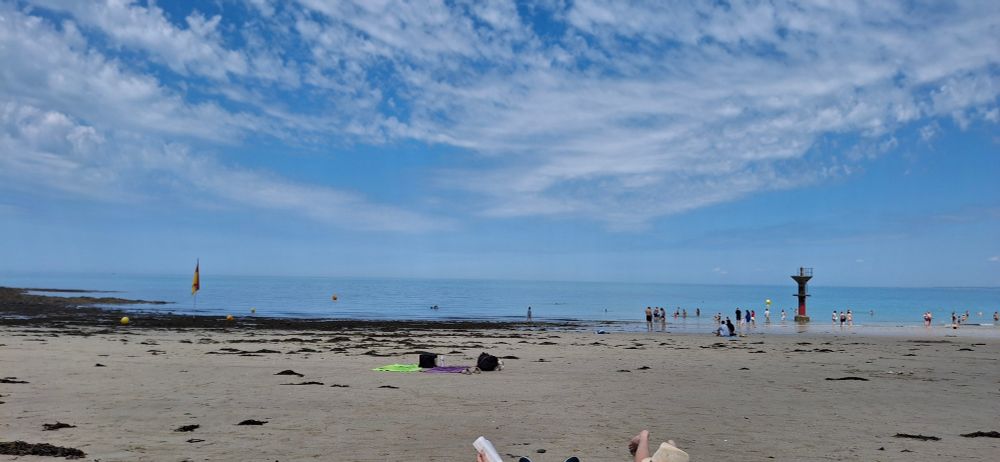 A sand beach, the sea and sky with clouds