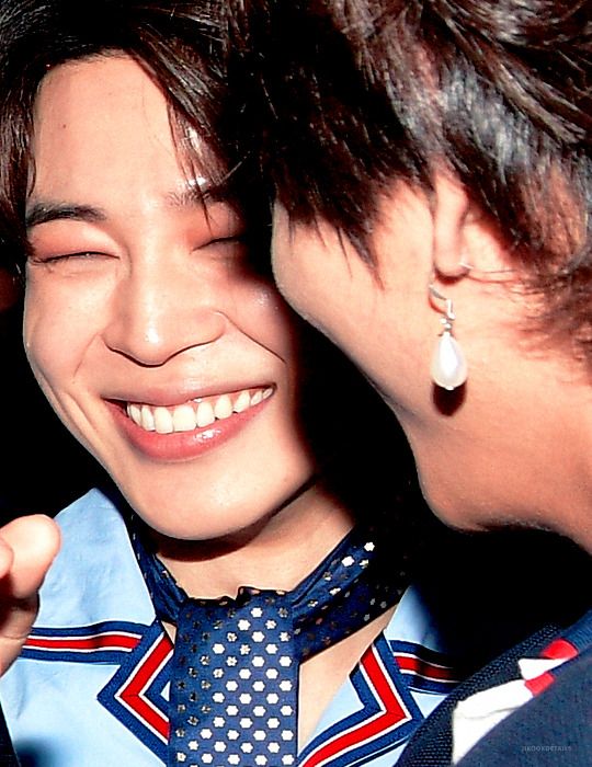 A close up photo of Kim Taehyung and Park Jimin smiling/laughing.
