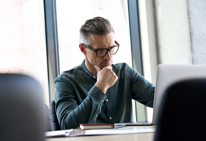 Stock photo of a man staring intently at his laptop computer 