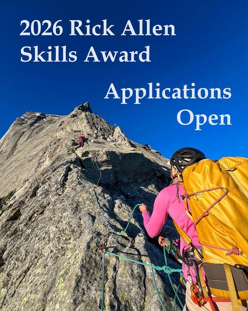 A picture of a climber on a ridgeline belaying their partner who is climbing several metres above them. At the top of the image, above a bright blue sky are the words: "2026 Rick Allen Skills Award, Applications Open'.