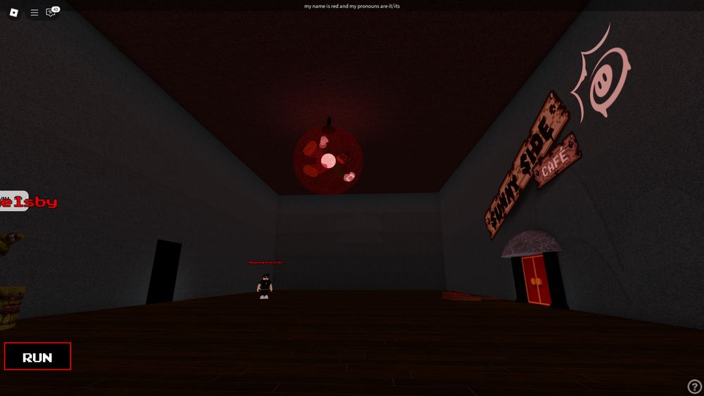 The darkened extras room, with a PS135 floating avobe the center of the room in a red sphere.