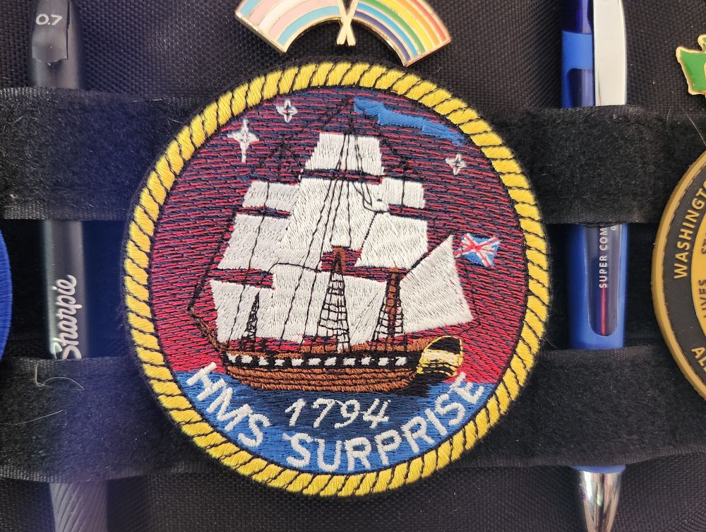 A photo of a round embroidered patch featuring the HMS Surprise from Patrick O'Brien's popular Master and Commander novel series. 