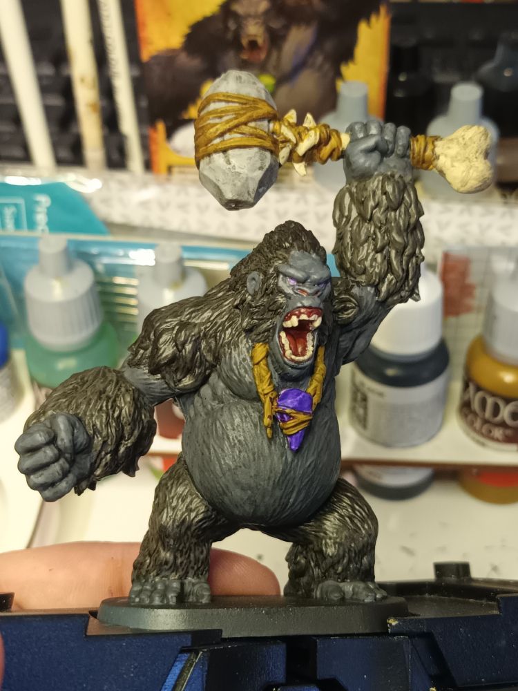 Large gorilla wielding a stone hammer made from a femur, leather straps, and a large rock. wearing a magical crystal around his neck

Handpainted mini front left view