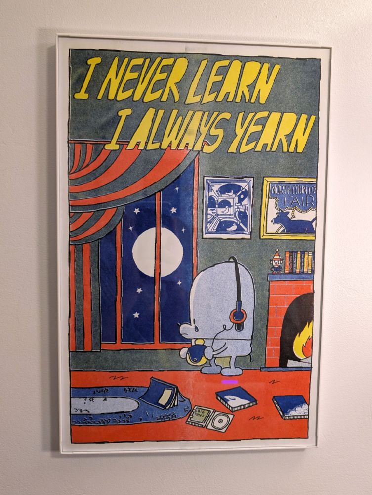a print that says "I Never Learn, I Always Yearn" with a sad dog in headphones (from Silver Sprocket)