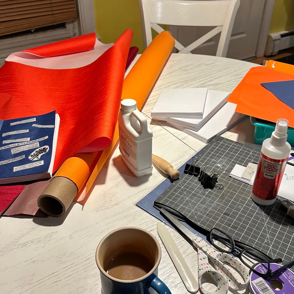 Photo of book making materials on a white table.