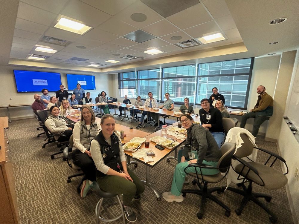 A group of hospitalists sitting eating a Thanksgiving meal together.
