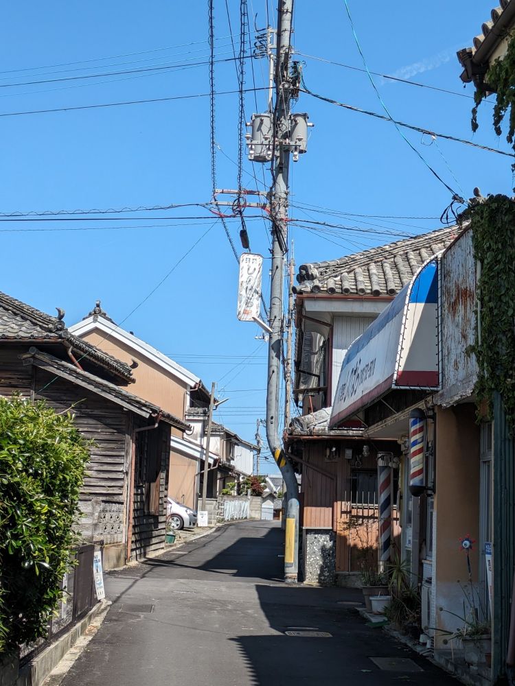 「へんな電柱」電柱が家に合わせて途中から曲がっている