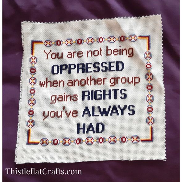 Completed cross stitch without frame with the words 'You are not being oppressed when another group gains rights you've always had' 