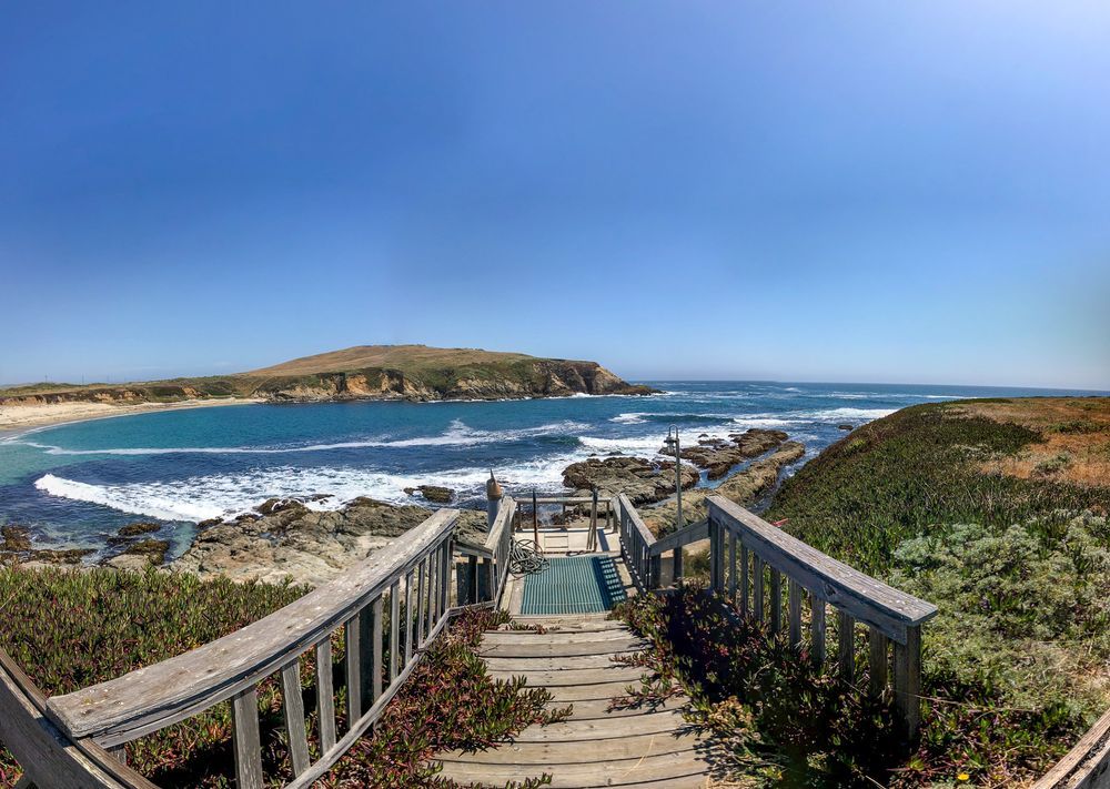 A panoramic view of Horseshoe Cove, looking down at a wooden platform that extends down the bluffs into the cove.