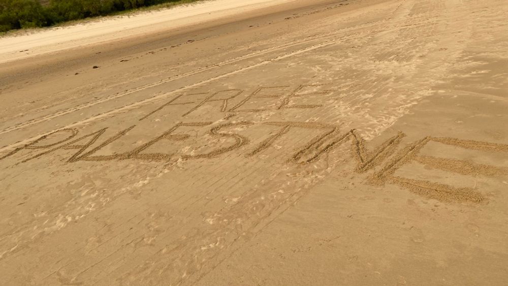 FREE PALESTINE escrito en la arena de la playa
