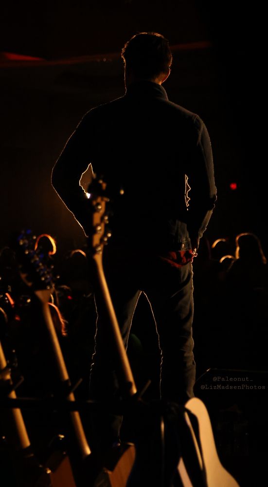 A photo taken from behind Jensen
looking out towards the audience
during the SNS - everything is dark
except for a glowing silhouette