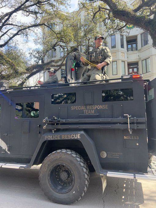 armored ice truck agents on top holding beads