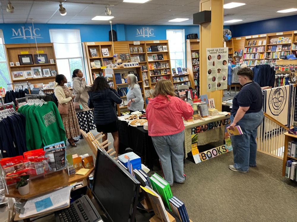 Folks gather around the refreshments & talk books!