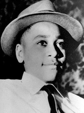 Black and white image of Emmett Till in hat, white shirt, and tie.