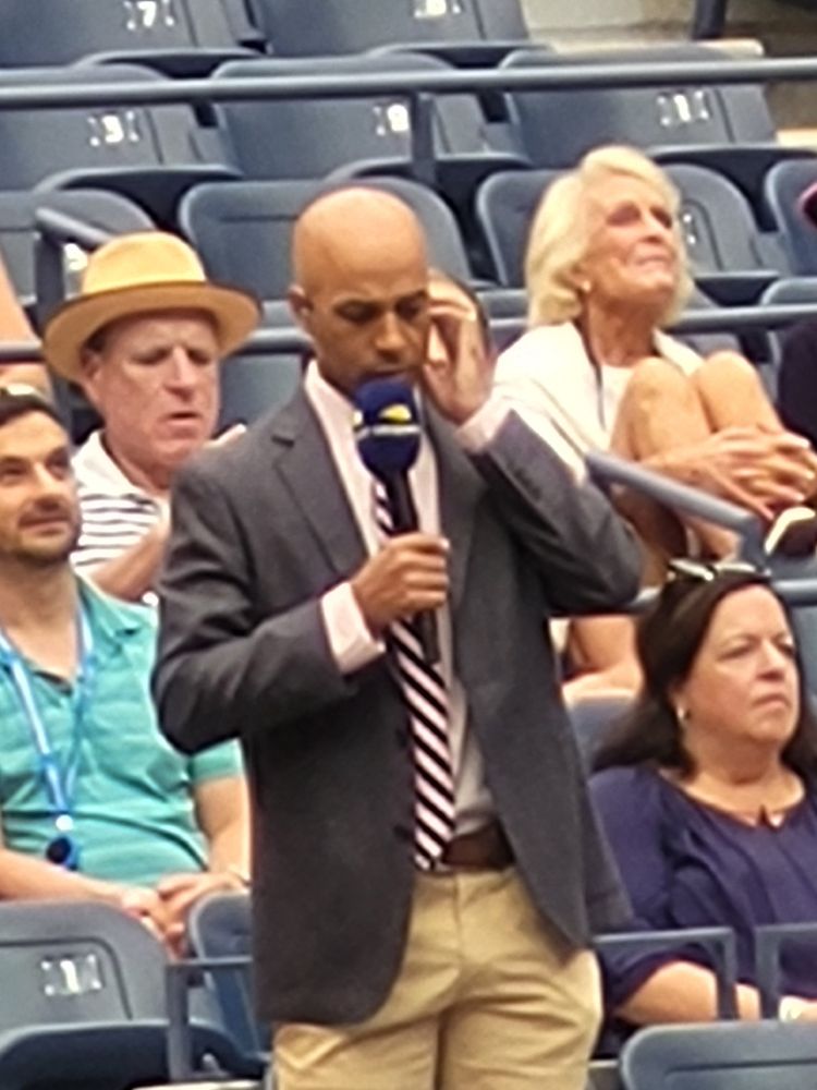 Picture of James Blake speaking into a microphone courtside at the US Men's Doubles final.
