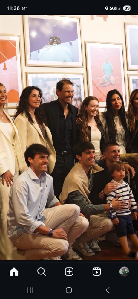 Picture of some of the Nadal family at Roland-Garros, including Rafa, his wife and sister in the back row. Standing in front is his son, Rafa, in a black and white horizontal shirt, and shorts. Looking very cute.