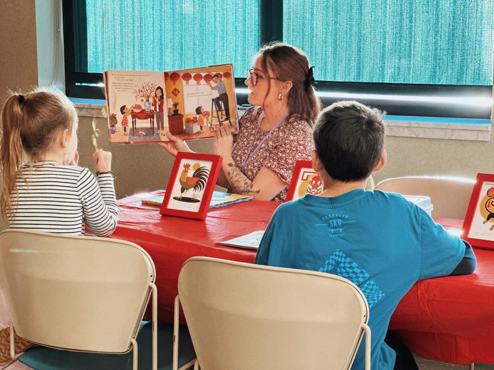 The Children’s Department reading a Lunar New Year book to two children from the community.