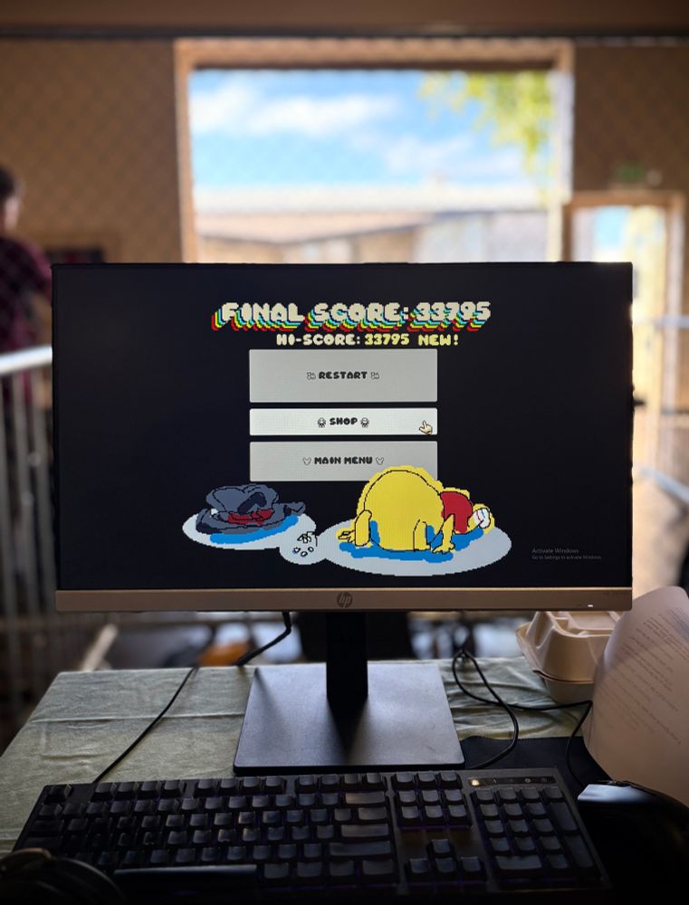 A close up of the game over screen for Blocks for Babies, against a blurred backdrop of Open Sauce being torn down
