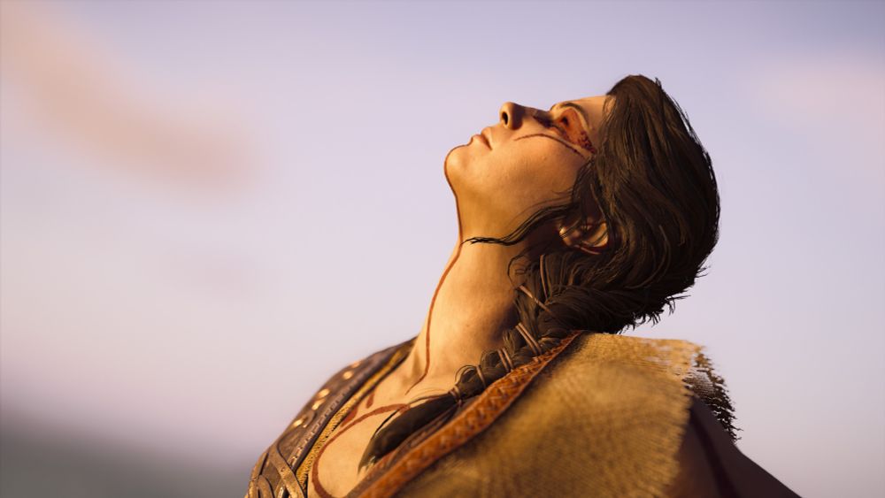 Side portrait of Kassandra wearing the Hunter's outfit, eyes closed, face to the sky, sunbathing.