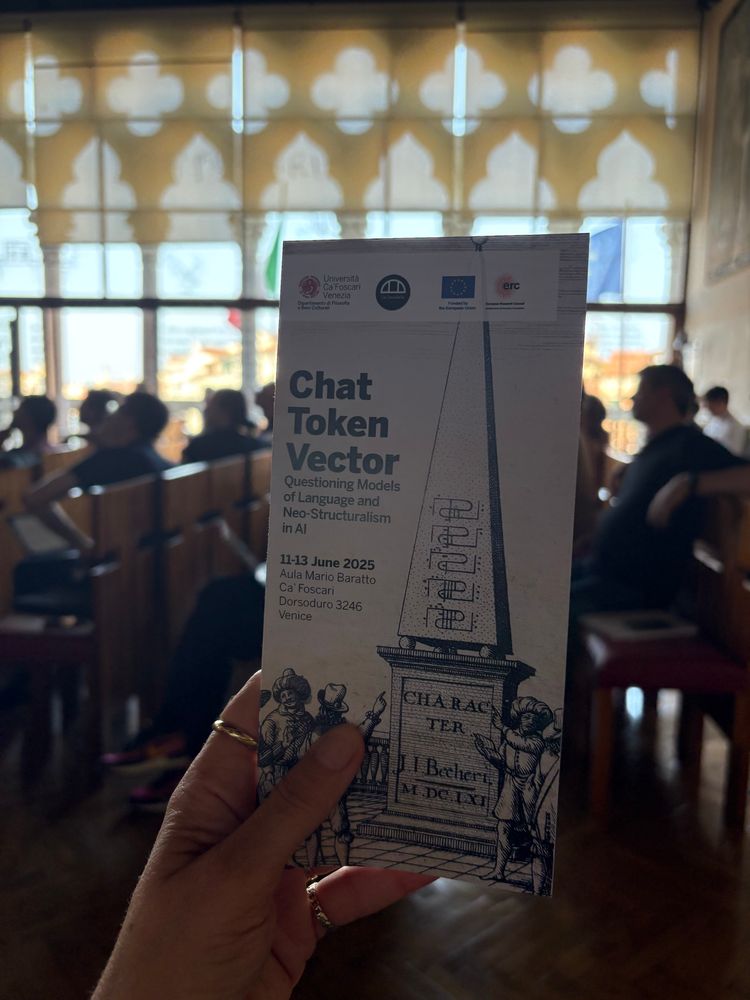 Hand holding up the program of the conference ‘Chat Token Vector’. 