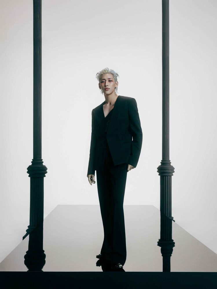 BamBam standing between what looks like a couple of streetlight poles idk, he looks stunning and is serving so much face that I don't care about the background 