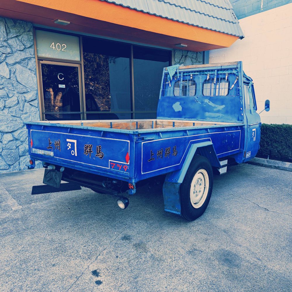 A vintage blue Mazda T1500 kei truck is sitting in front of a local auto repair shop by the train tracks in San Mateo. This area is zoned for light industrial use and the chunky truck fits right in with the vibe.