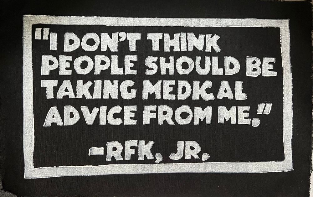 Black cloth patch with lettering in white fabric ink. Will pass these out at actions.