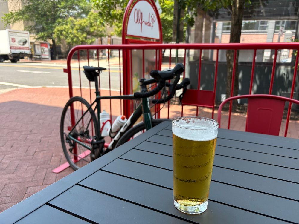 a beer (peroni) in a glass sitting on a table in front of a road bike at Alfreda pizza in dupont circle