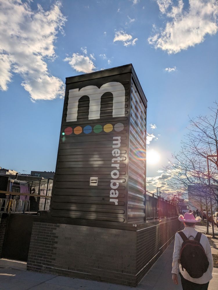 The metro bar tower, a prominent DC bar themed around the Metro, with a shining sun behind it 