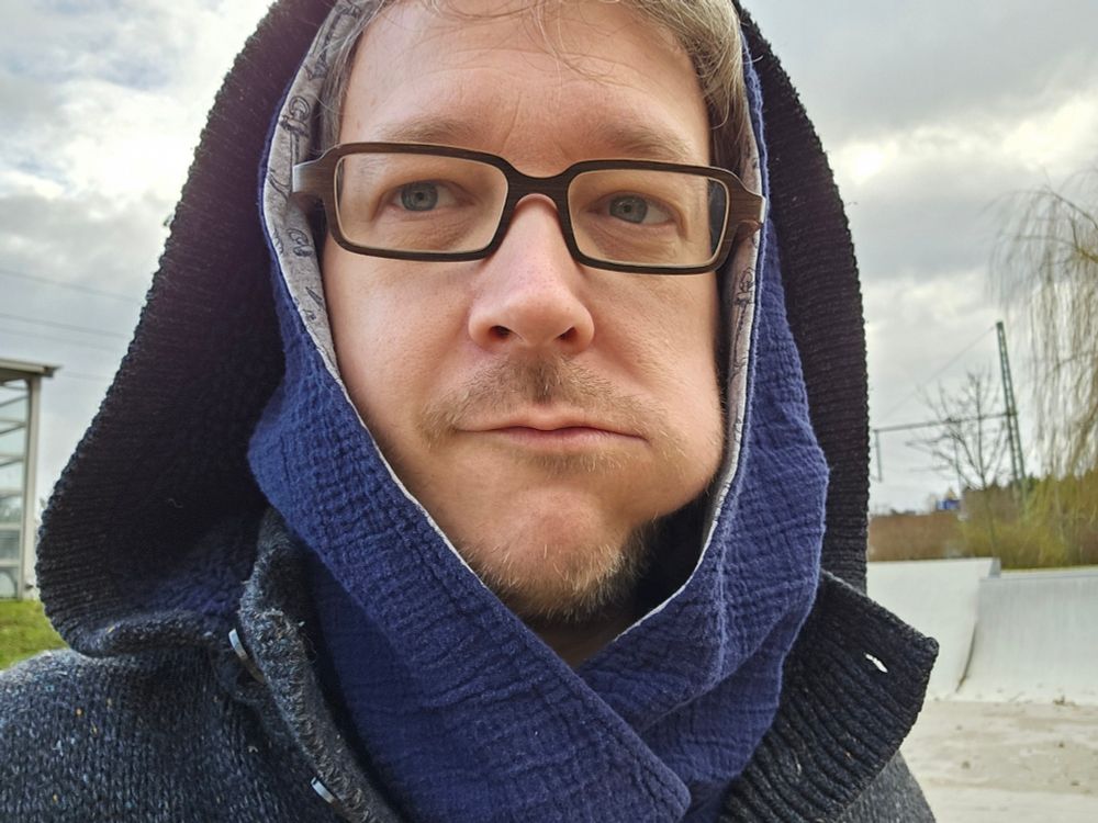 Ich, im Hoodie, eine Backe ist etwas auffällig ausgebeult.