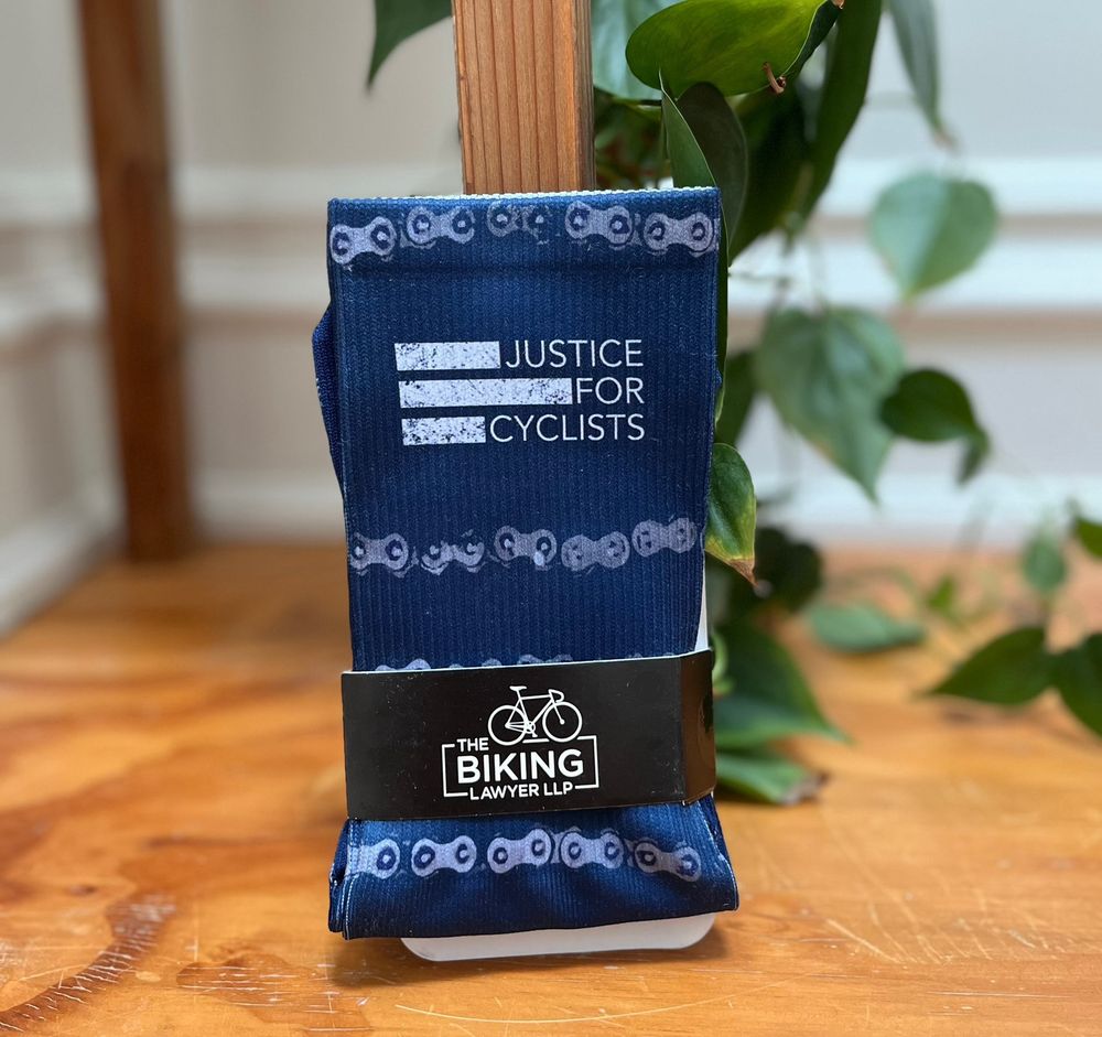 An image of socks that say “justice for cyclists”