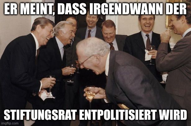 Mehrere lachende Männer auf einem Foto mit dem Text: „Er meint, dass irgendwann der Stiftungsrat entpolitisiert wird“