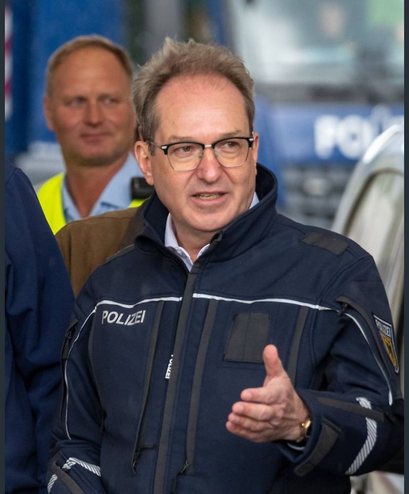 Dobrint in einer blauen Dienstjacke der Polizei.