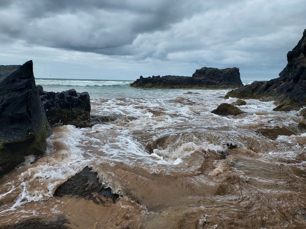 Shoreline of rocks, waves and darkening clouds anove
