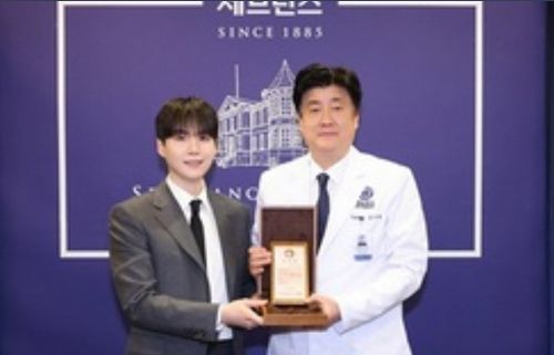 Article is being stubborn about posting so have just the pic of Yoongi with the hospital rep holding a plaque thing - Yoongi is dressed in a dark gray suit, black tie, white shirt, plain black hair w/bangs cuz military time.  There is a purple backdrop with the hospital on it behind them. 
