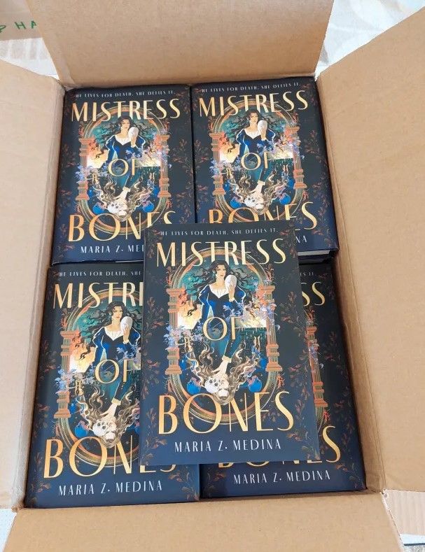 Open cardboard box full of hardcover editions of Mistress of Bones.