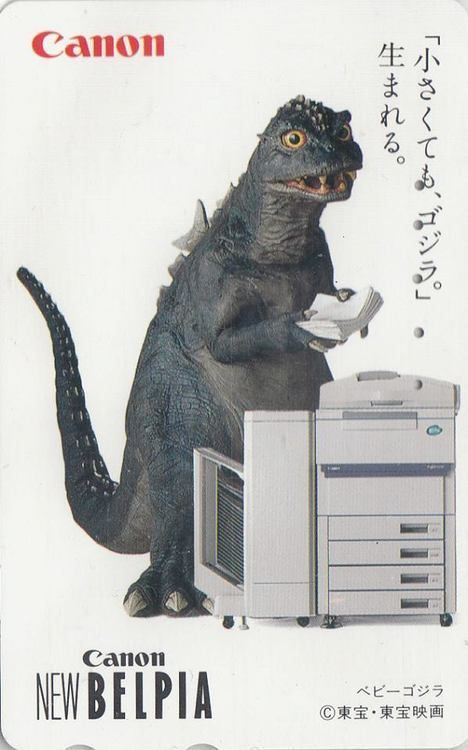 An old Canon from 1993 with rubber model kaiju, Godzilla's son, Minila ( I thiiink?) stood next to a compact copier (New Belpia) looking a bit puzzled as Trey hold up a pile of papers.