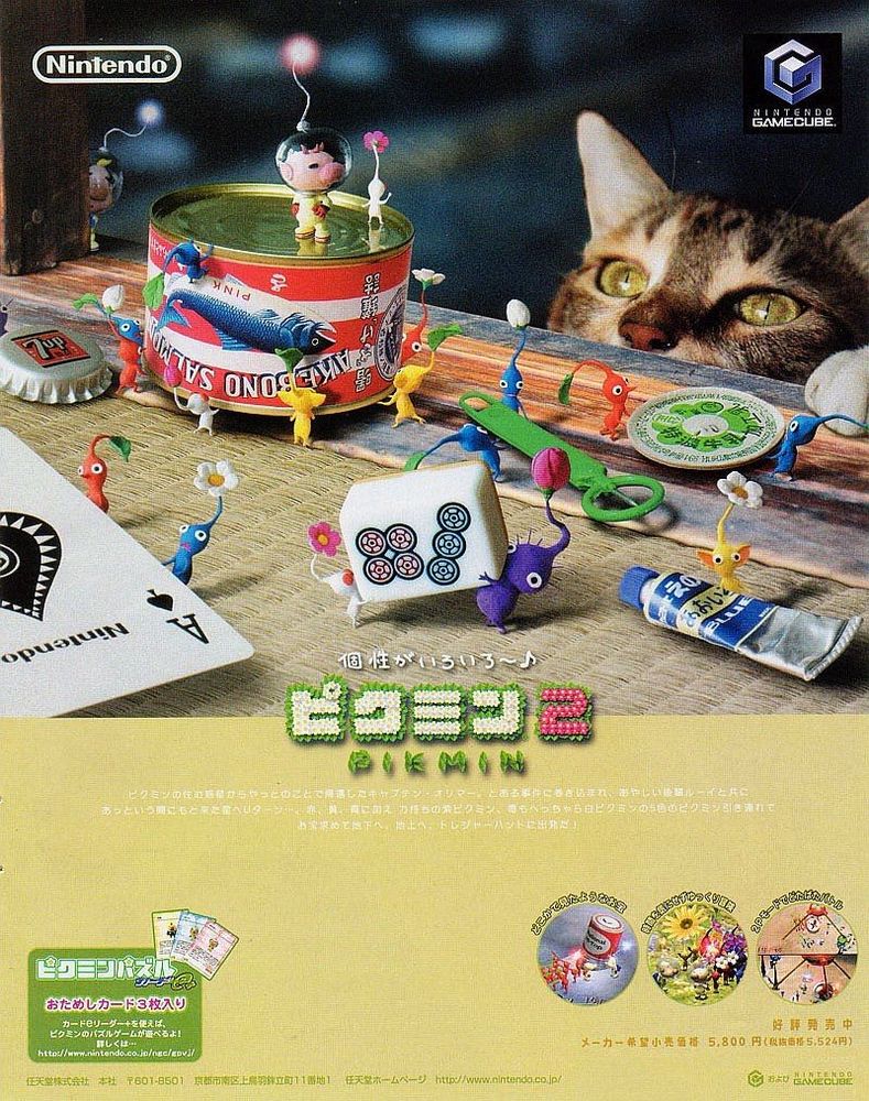 A Japanese ad for Pikmin 2 with rendered characters on a real-life kitchen tabletop with a tin of salmon and various things like bottle tops and can openers, and some other bits of household things being carried away by Pikmin. A cat is peeking up over the edge and looking amazed, potentially horrified.