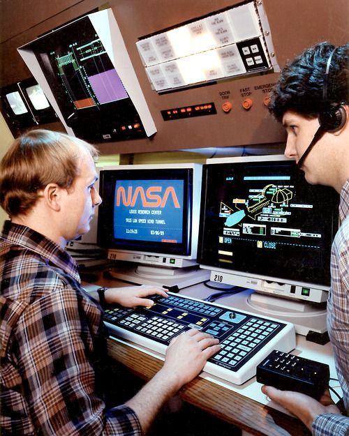 A photo dated 1989 of two guys in comfy plaid check shirts at a pair of crt monitors (black frame with white casing), one pressing buttons on a slanted keyboard that has a bit of a retro feel even for 1989 while the other sports a headset and holding a black box. Vibrant and share schematics of a wind tunnel can be seen on one screen while a blue background with the red NASA worm logo is displayed on the other.

credit Glenn Research Centre collection on IA.