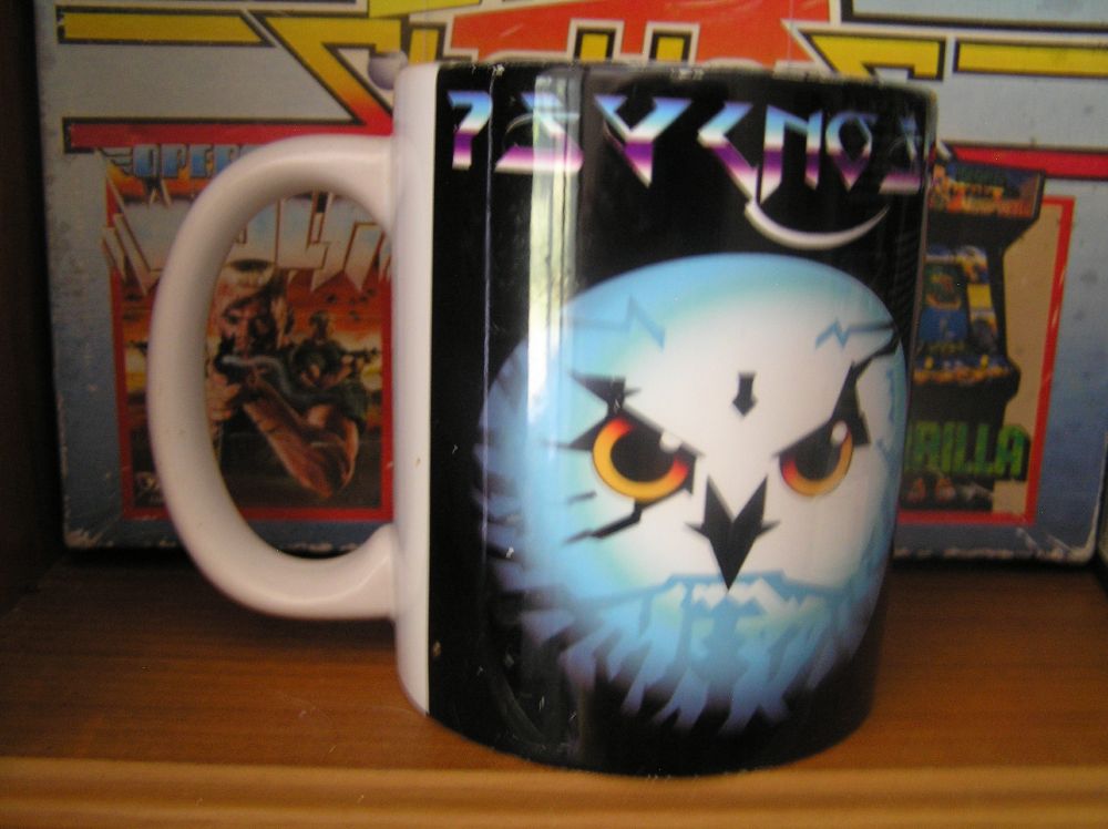 A photo of a Psygnosis themed mug with the owl logo and stylised text