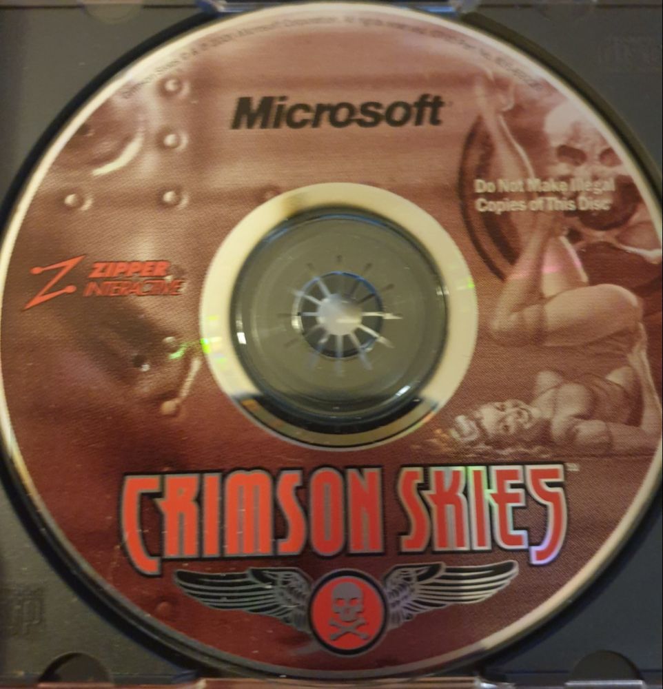 A photo of the the gorgeous CD artwork with its moody red and metal riveted plane chassis background with a WW2-style pinup gal on it.