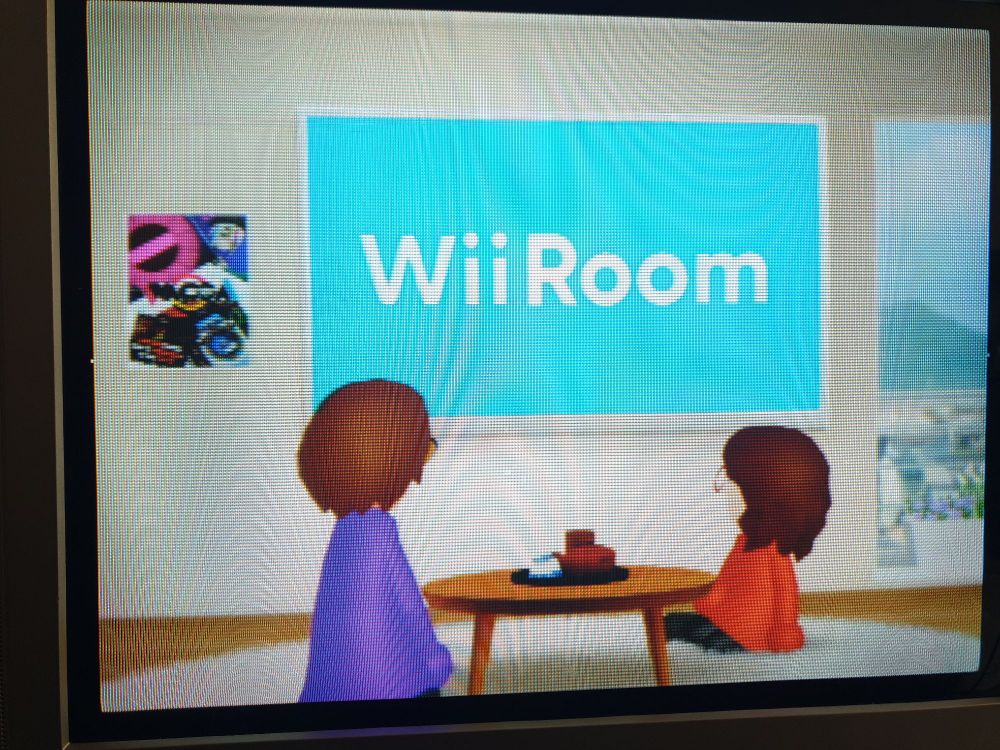 A crt TV screenie of the virtual home environment with Miis and a large media screen on a wall 