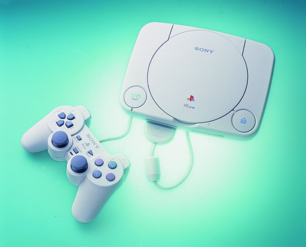 A high resolution photo of a PSOne and its controller against a lime green backdrop with a bloom of whiter light in the middle