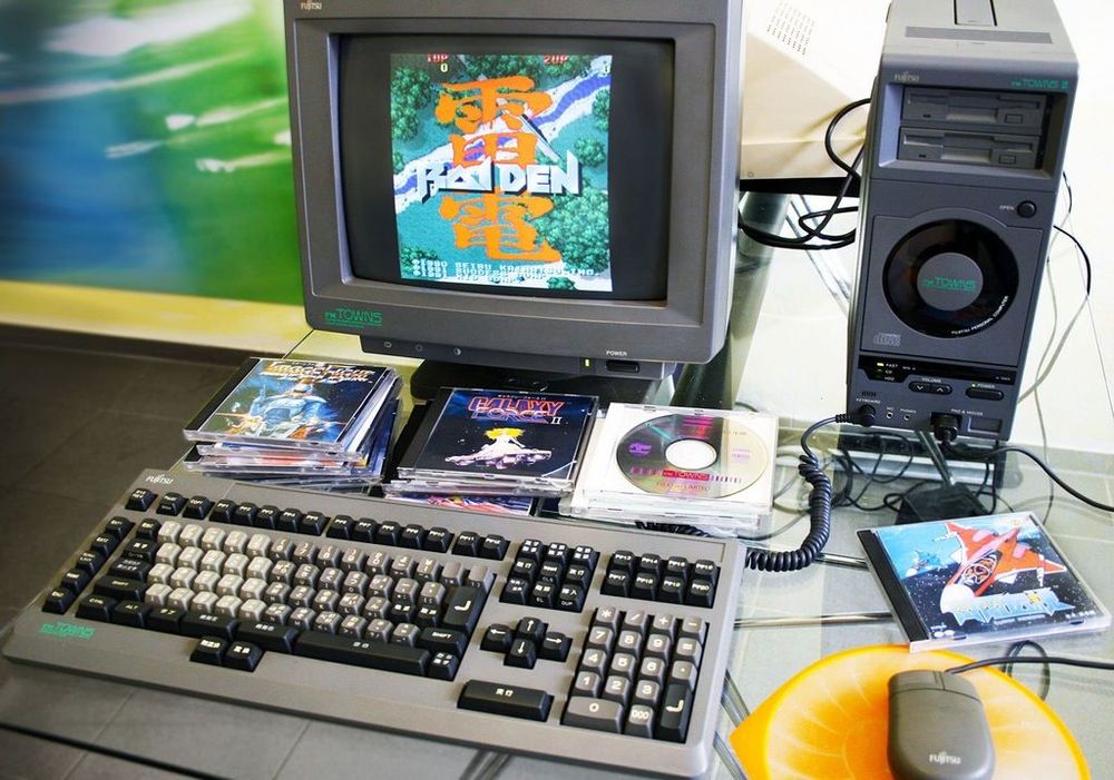 A photo of a Fujitsu FM Towns PC with keyboard, monitor, mouse and tower with tons of CD games in front of it in piles and Raiden on the screen.

Photo source: Resetera.