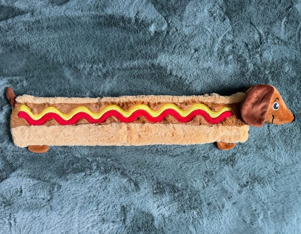 long hot water bottle cover in shape of a dachshund in a hot dog bun with mustard and ketchup