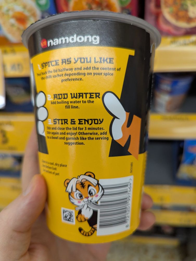 namdong chicken noodles with cute tiger graphic. in this picture the tiger is eating the barcode like noodles 