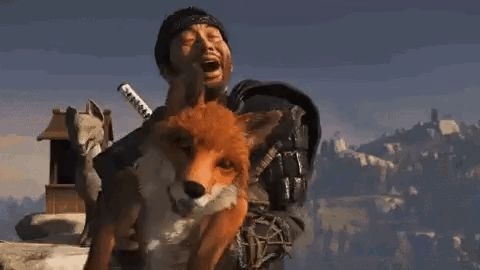 a man is holding a fox in his arms and laughing .