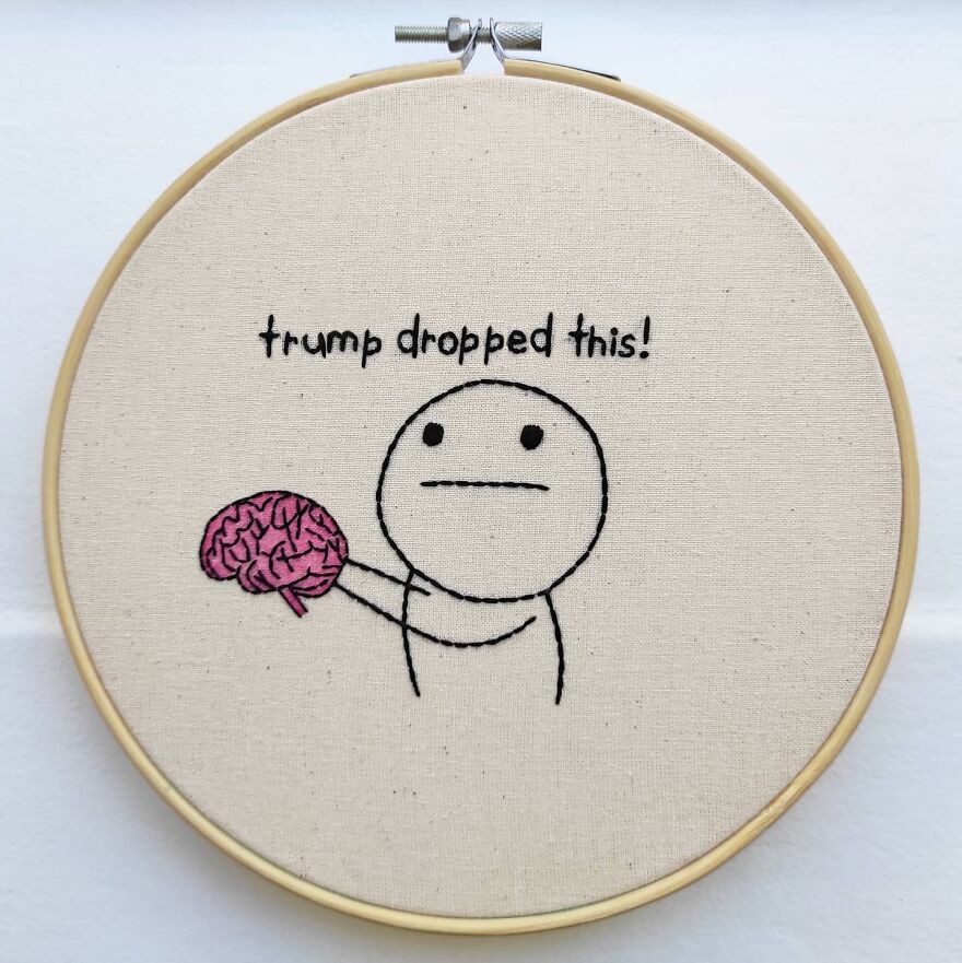 a needlepoint with a guy holding up a brain and it says 'trump dropped this!'