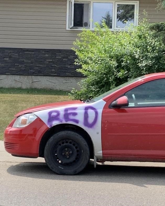 Part of the outside of a red car was replaced with a white panel so they spray painted the word 'red' on the panel