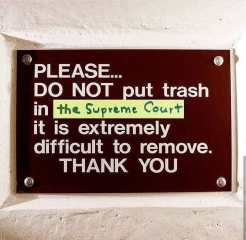 a sign that someone put yellow tape with "the supreme court' on

so it says

please...
do not put trash in the supreme court it is extremely difficult to remove. 
THANK YOU